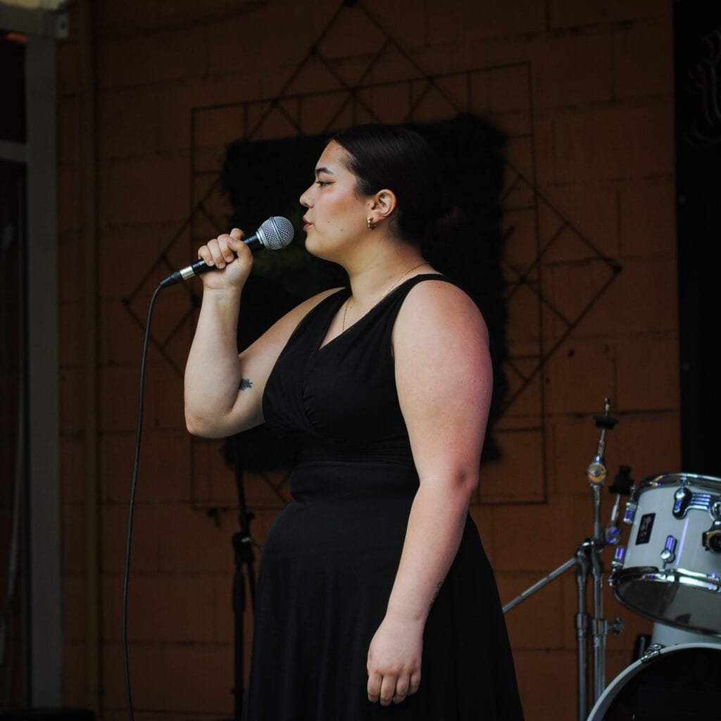 clases de canto en madrid mujer cantando en un micrófono durante una clase de canto